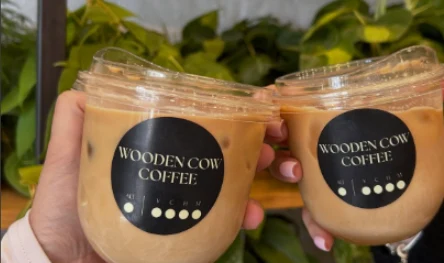 Wooden Cow Coffee cups raised in a toast